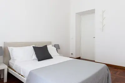 a bedroom with a white bed with a black pillow at B&D Dolce Vita in Rome