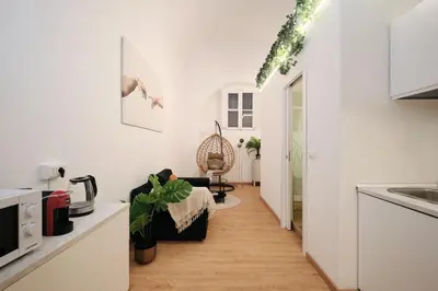 a kitchen and living room with white walls and wooden floors at 3' to Colosseum Bohèmien Paradise in Rome