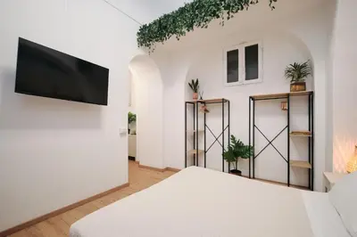 a room with a bed and a flat screen tv at 3' to Colosseum Bohèmien Paradise in Rome