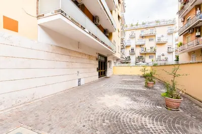 an empty courtyard of a building with potted plants at Royal Vatican house JND in Rome