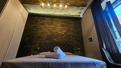 a bedroom with a large bed with a brick wall at vatican street art in Rome