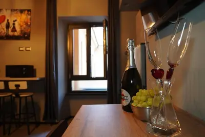a table with two wine glasses and a bowl of grapes at vatican street art in Rome
