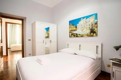a bedroom with a white bed and a painting on the wall at Imperial House in Rome