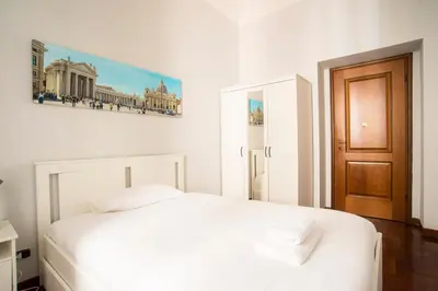 a bedroom with a white bed and a painting on the wall at Imperial House in Rome