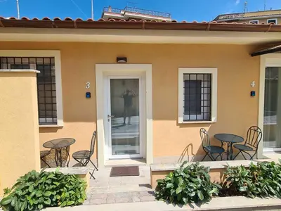 a patio with chairs and tables in front of a house at Gemelli BnB Guest House in Rome