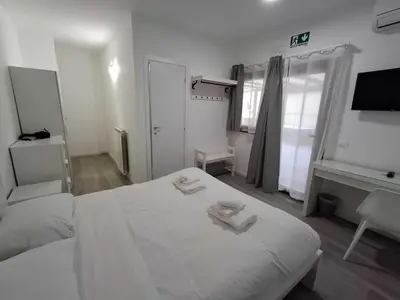 a bedroom with a white bed with two towels on it at Gemelli BnB Guest House in Rome