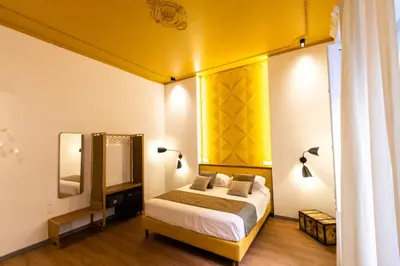 a bedroom with a bed and a yellow wall at Trevi Monti House in Rome