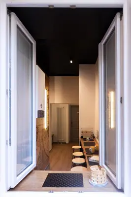 a room with large windows and a table and chairs at Trevi Monti House in Rome
