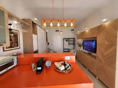 a living room with an orange couch and a tv at Venus Inn Casa Vacanze AURELIA ANTICA in Rome