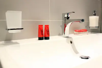 a bathroom sink with two toothbrushes and a faucet at Hub Navona in Rome