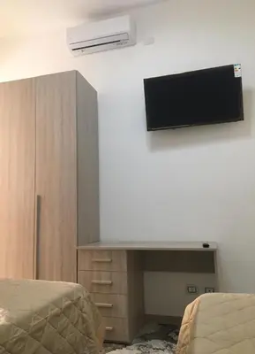 a room with two beds and a tv on the wall at Bed&Breakfast MENNA in Rome