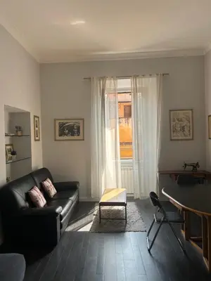 a living room with a couch and a table and a window at Ripetta 24 in Rome