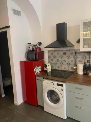 a kitchen with a washing machine and a red refrigerator at nel cuore di trastevere in Rome