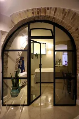 a glass door in a room with a bedroom at DomusLatina Monti - Luxury stay in the heart of Rome in Rome