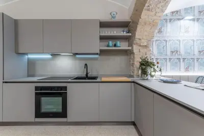 a kitchen with white cabinets and a sink and a window at DomusLatina Monti - Luxury stay in the heart of Rome in Rome