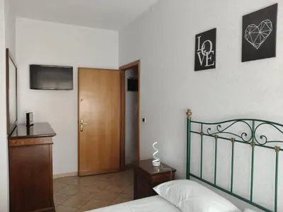a bedroom with a bed and a wooden door at House For You in Rome