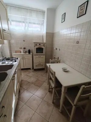 a kitchen with a table and a sink and a stove at House For You in Rome