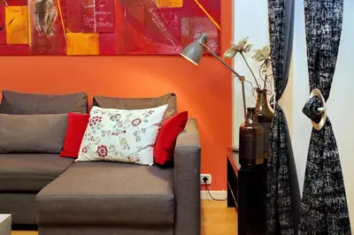 a couch in a living room with an orange wall at Apartment Vespucci in Rome