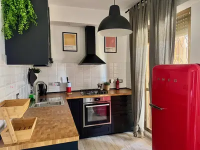 a kitchen with a red refrigerator next to a sink at Cozy Apartment with Metro Link to the Colosseum in Rome