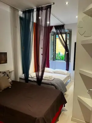 two beds in a room with curtains and a window at Procida's House by ACS HOLIDAYS in Rome