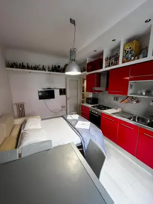 a kitchen with red cabinets and a table in a room at Procida's House by ACS HOLIDAYS in Rome