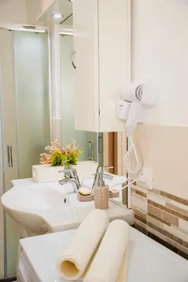a bathroom with two sinks and a mirror at Domusky Attico - 8 piano in Rome