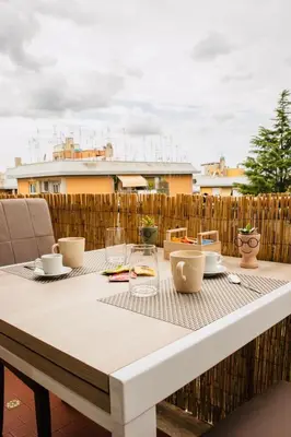 a table with cups and dishes on a balcony at Domusky Attico - 8 piano in Rome