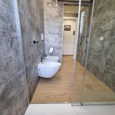 a bathroom with a sink and a glass shower at Suite Station Tiburtina in Rome