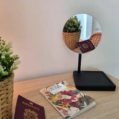 a mirror sitting on a table next to a book at Suite Station Tiburtina in Rome