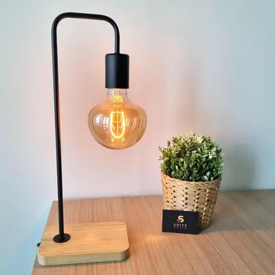 a lamp on a table next to a potted plant at Suite Station Tiburtina in Rome