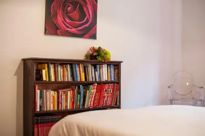 a book shelf filled with books next to a bed at Great Apartment in great Location in Rome