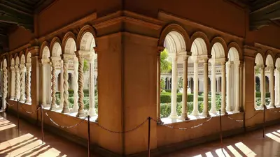 a building with columns and arches and a fence at Suite Mario - Colosseo in Rome