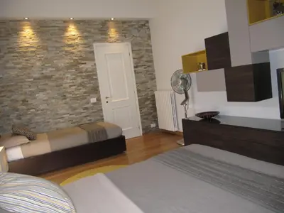 a bedroom with two beds and a brick wall at Matteo al Vaticano Vicino Metro in Rome