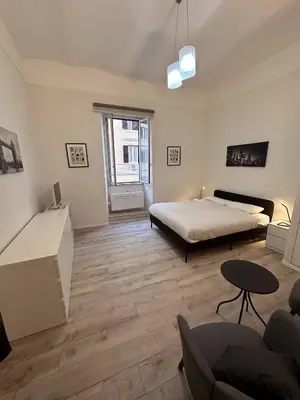 a bedroom with a bed and a living room at PGL San Lorenzo in Rome