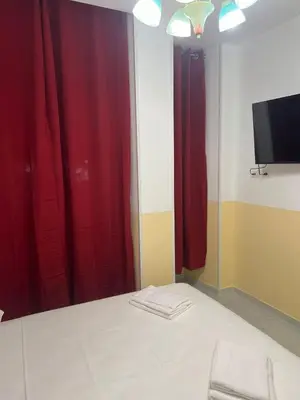 a room with red curtains and a flat screen tv at SALENTINI APPARTAMENTo in Rome