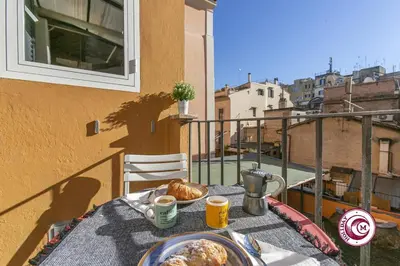 a table with a plate of food on a balcony at C M Fori Imperiali Apartment in Rome
