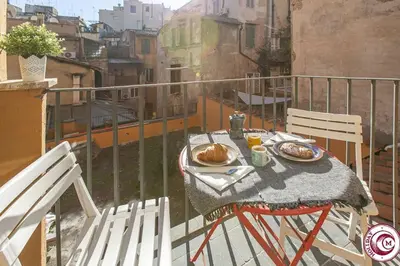 a table with plates of food on a balcony at C M Fori Imperiali Apartment in Rome