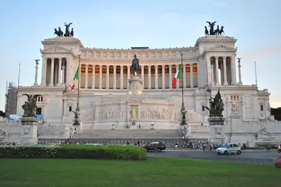 a large building with flags in front of it at RHOMENJOY Open Space Colosseo in Rome