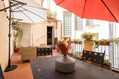 a vase on a table with an umbrella on a balcony at Sant'Angelo Terrace Apartment in Rome