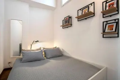 a bed in a room with pictures on the wall at Sant'Angelo Terrace Apartment in Rome