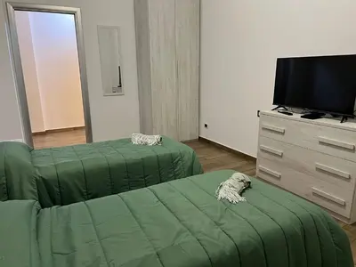 a living room with a green couch and a tv at Roma nel Mondo in Rome
