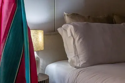 a bed with a white pillow and a lamp at iFlat Pantheon Elegant 3-bedroom Apartment in Rome