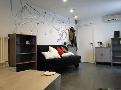 a living room with a black couch and musical notes on the wall at Jazz Style Home in Rome