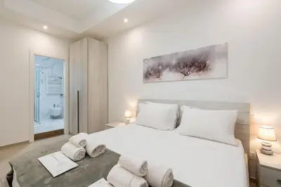 a white bedroom with a large bed and a bathroom at Metro A 1 min - Casa Elegante - 3 bagni En Suite in Rome