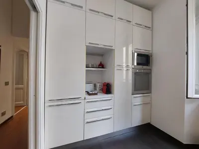 a white kitchen with white cabinets and appliances at Nel cuore del Vaticano spazioso ed elegante in Rome