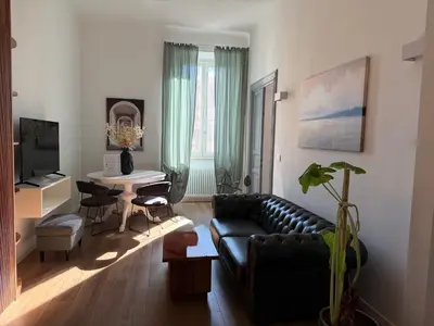 a living room with a black leather couch and a table at a casa di Manuela luxury apartment in Rome