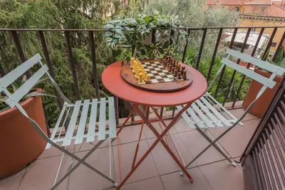 a chess board on a table on a balcony with two chairs at Vittoria Urban Chic - elegant apartment in the heart of Rome in Rome