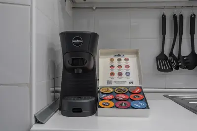 a black coffee maker next to a box of donuts at Vittoria Urban Chic - elegant apartment in the heart of Rome in Rome