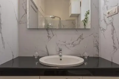 a bathroom with a white sink and a mirror at Vittoria Urban Chic - elegant apartment in the heart of Rome in Rome