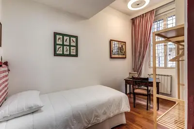 a bedroom with a bed and a desk and a window at Domus in Via Del Corso in Rome